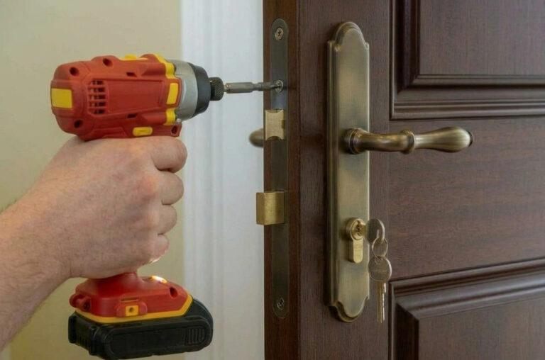 Serrurier remplaçant une serrure en mortaise sur une porte traditionnelle en bois à Amiens